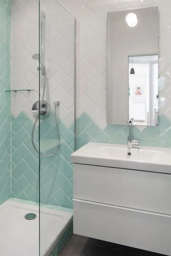 Banheiro com revestimento verde e branco formato geométrico