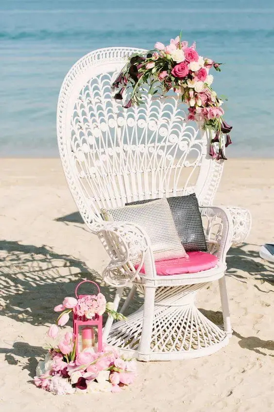 Cadeira para área externa de vime na praia decorada com flores cor de rosa