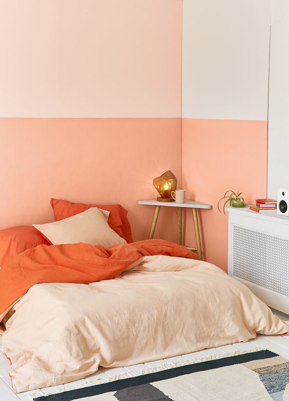 Cor coral na parede e roupa de cama do quarto moderno