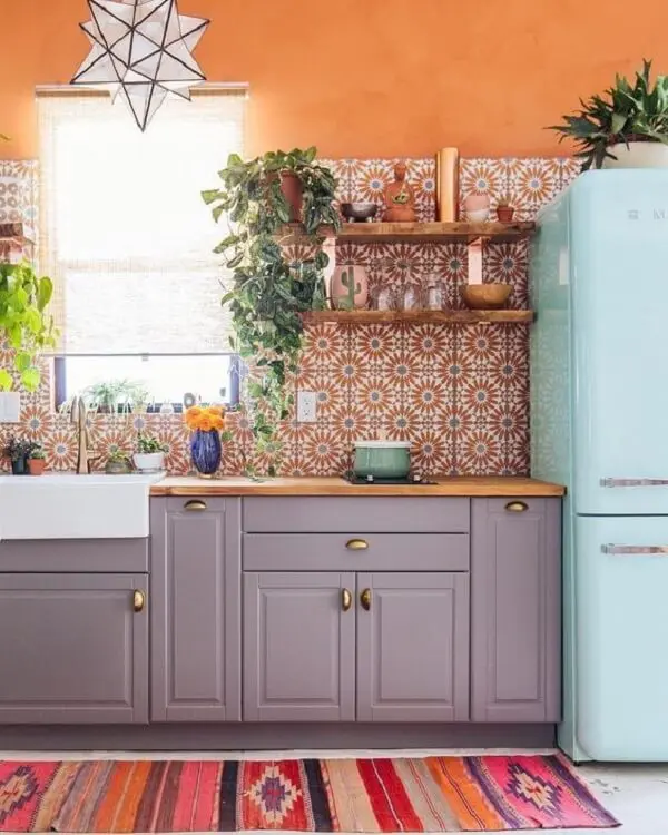 Cozinha com azulejo antigo com nuances de laranja alegram a decoração