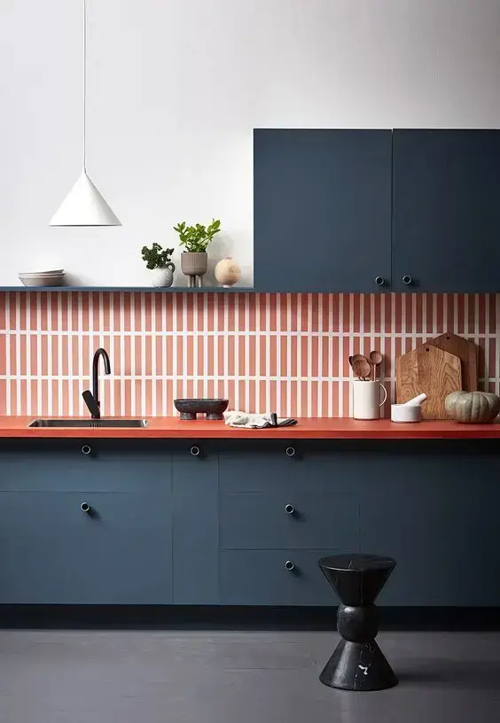 Cozinha com revestimento na cor coral e armários azuis