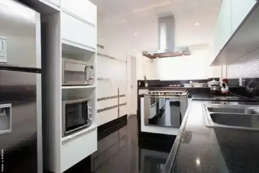 Decoração de cozinha com piso preto e armários planejados