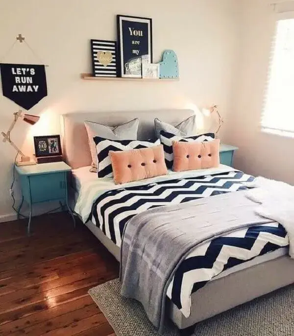 Decoração de quarto simples de casal com quadros, almofadas e mesa de cabeceira retrô azul