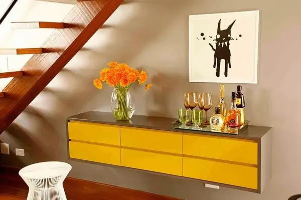 Modelo de aparador bar amarelo suspenso otimiza o espaço do cômodo