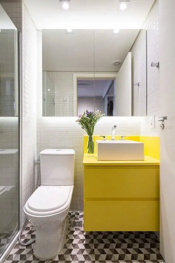 Modelo de armário suspenso basculante amarelo com porta invertida decora e organiza o banheiro