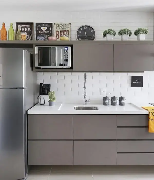 O armário de cozinha basculante acima da bancada otimiza o espaço do ambiente