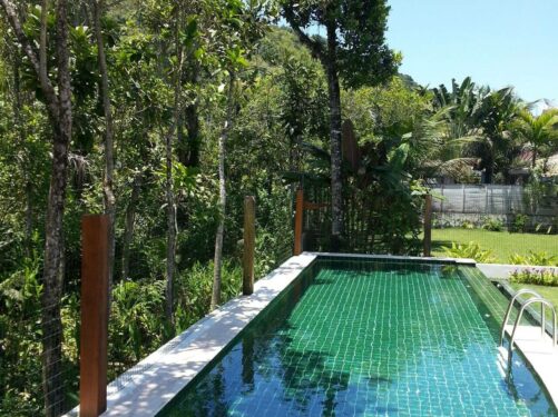 O azulejo para piscina verde conversa com a paisagem do local