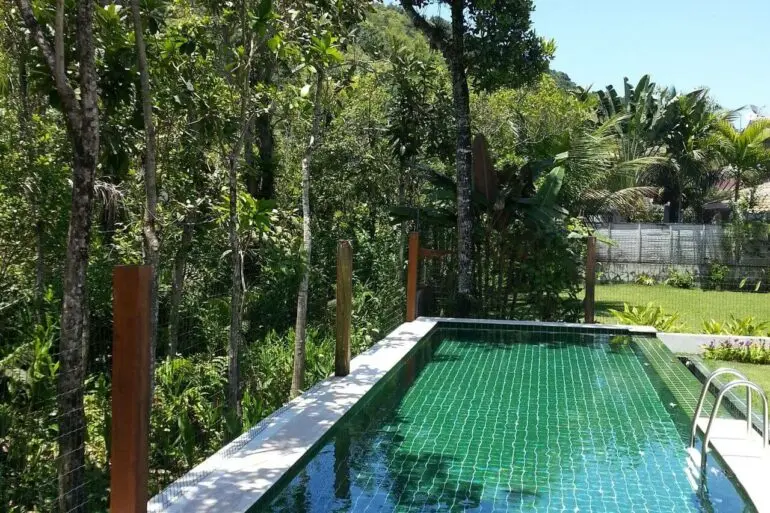 O azulejo para piscina verde conversa com a paisagem do local