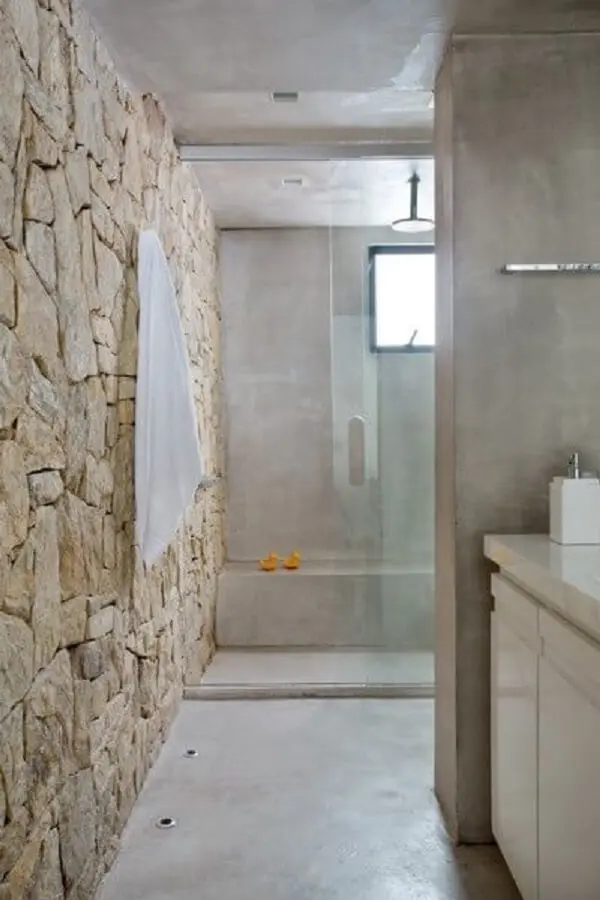 O revestimento de pedra decora o banheiro desse imóvel