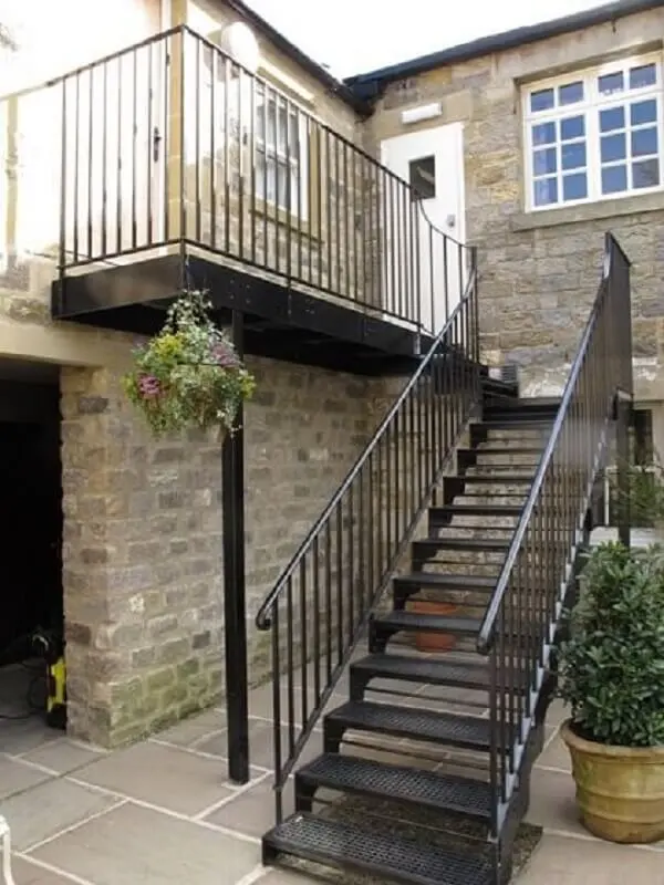 O revestimento para escada de ferro leva à parte de trás da casa