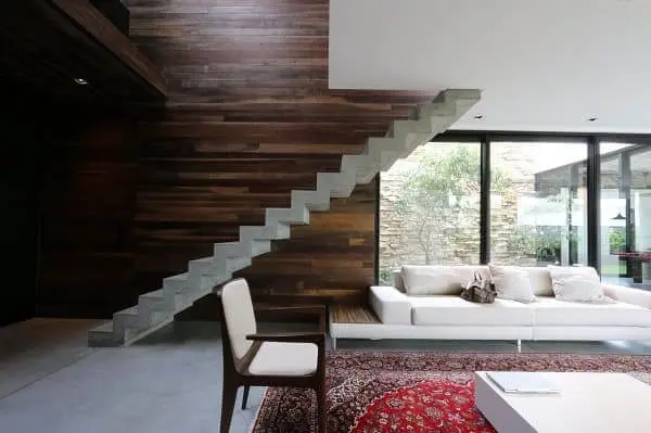 O revestimento para escada pré-moldada reta invade a decoração dessa sala de estar