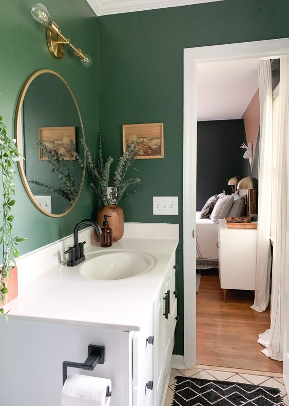 Parede verde com gabinete de banheiro branco