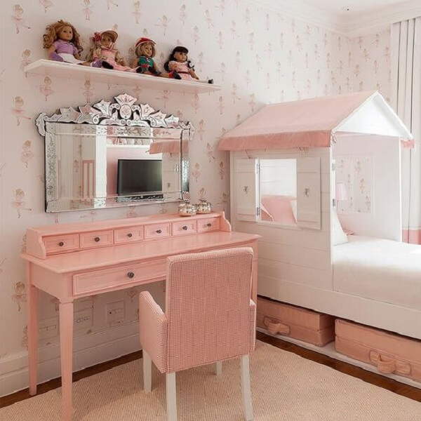 Penteadeira cor de rosa com espelho decora o quarto de menina