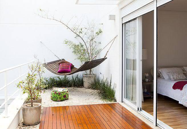 Quarto com varanda decorada com rede para relaxar