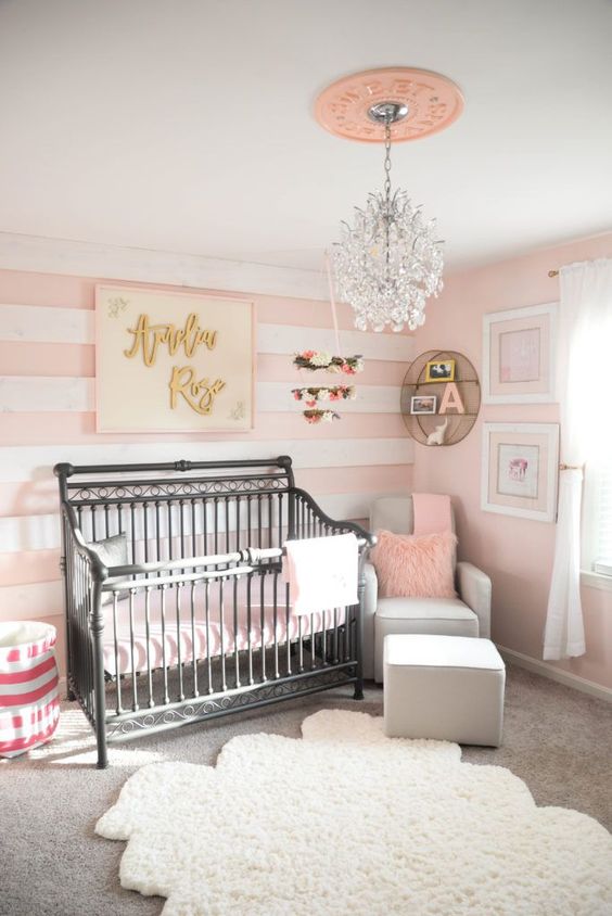 Quarto de bebe com papel de parede rosa listrado