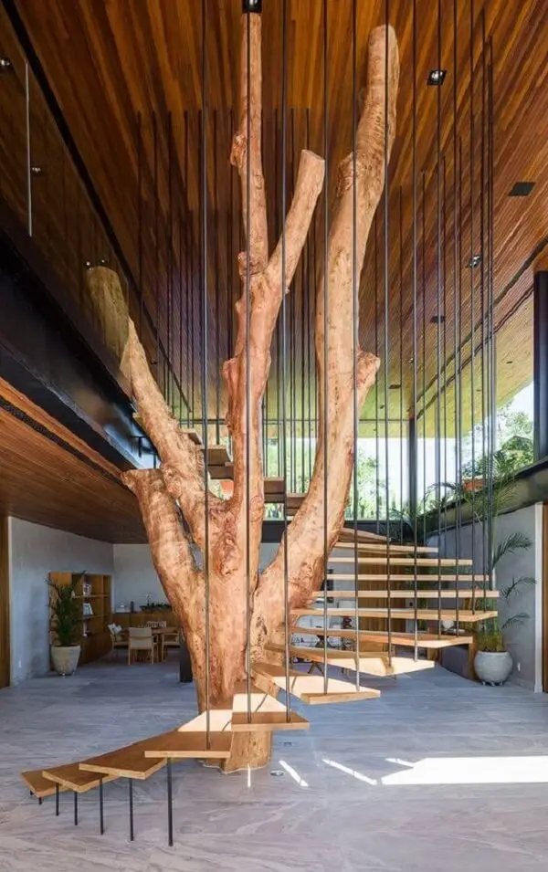 Revestimento para escada interna feita em madeira foi construída ao redor da árvore da sala