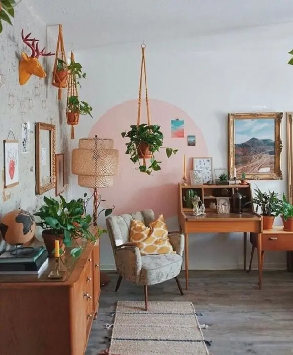 Sala com poltrona pé palito e decorada com inúmeras plantas