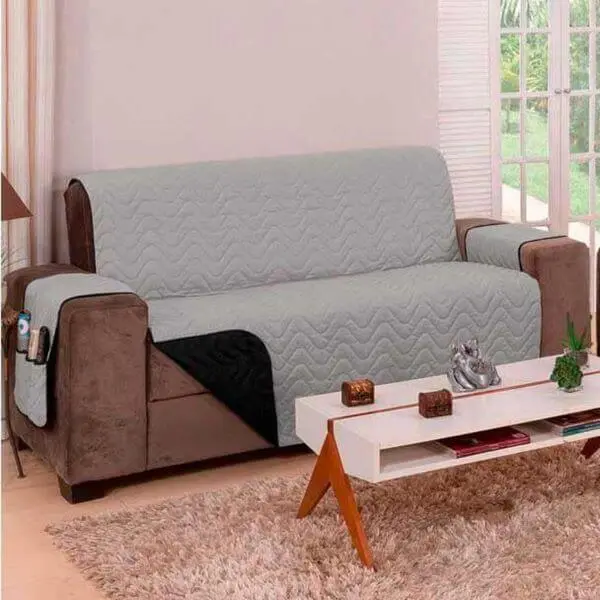 Sala com sofá marrom e capa impermeável cinza