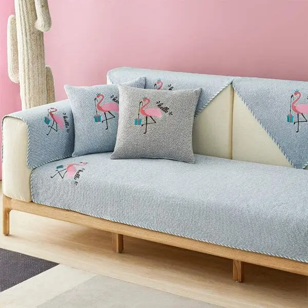 Sala rosa com capa de sofá azul claro e estampa de flamingo