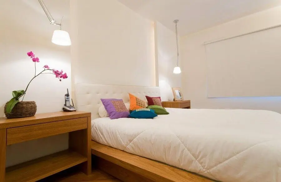 Almofadas coloridas para decoração de quarto com cabeceira estofada branca