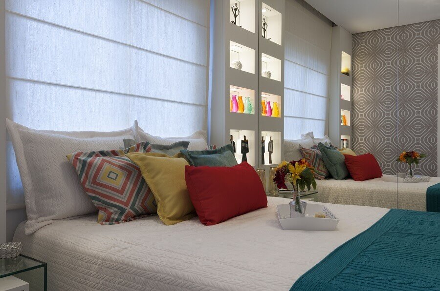 Almofadas coloridas para quarto branco decorado com guarda roupa espelhado