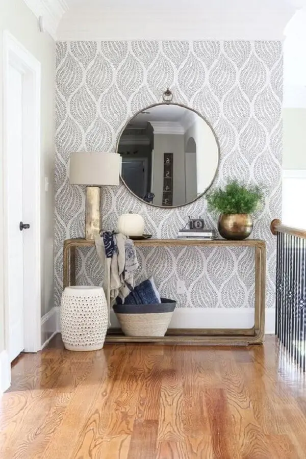Aparador com espelho redondo para corredor decorado com papel de parede cinza