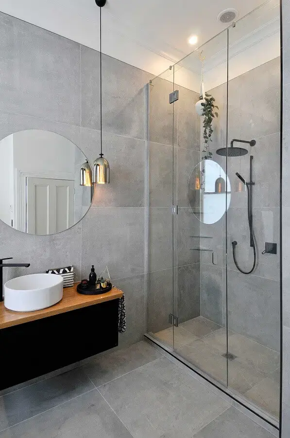 Banheiro cinza decorado com luminária moderna cromada