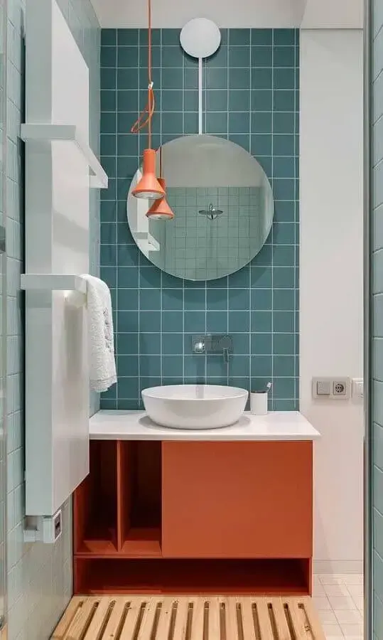 Banheiro colorido decorado com espelho redondo e luminária moderna de teto