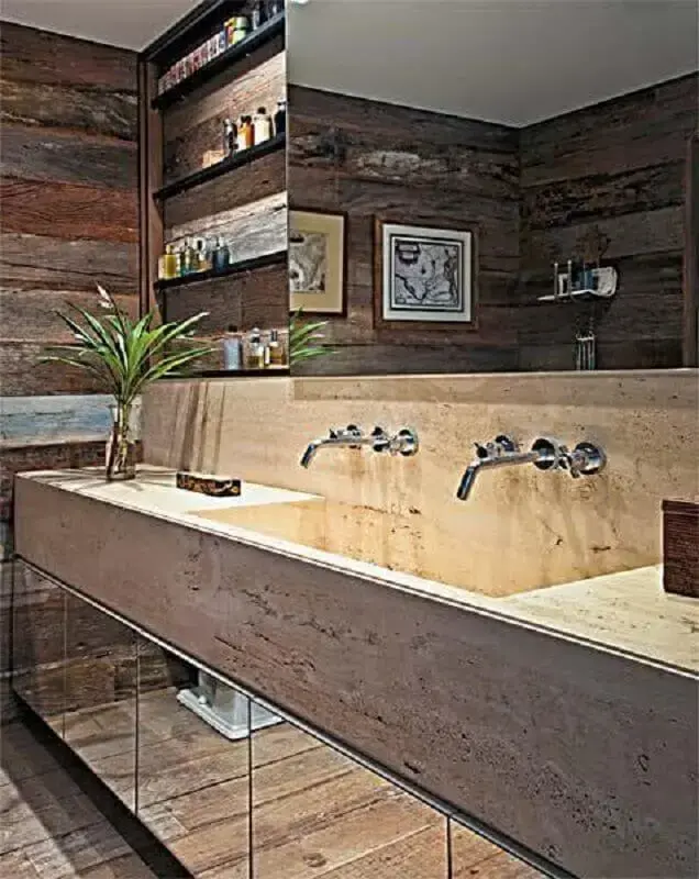 Banheiro decorado com bancada de mármore e parede com revestimento de madeira