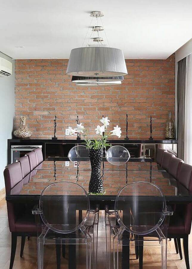 cadeiras diferentes para mesa de jantar em sala decorada com parede de tijolinho Foto Homeit