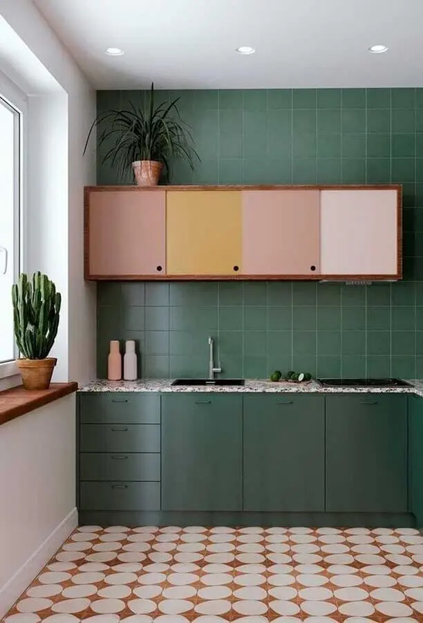 Cozinha cor verde escuro decorada com armário aéreo colorido