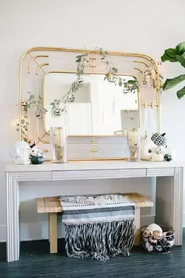 Decoração com aparador branco simples e espelho dourado