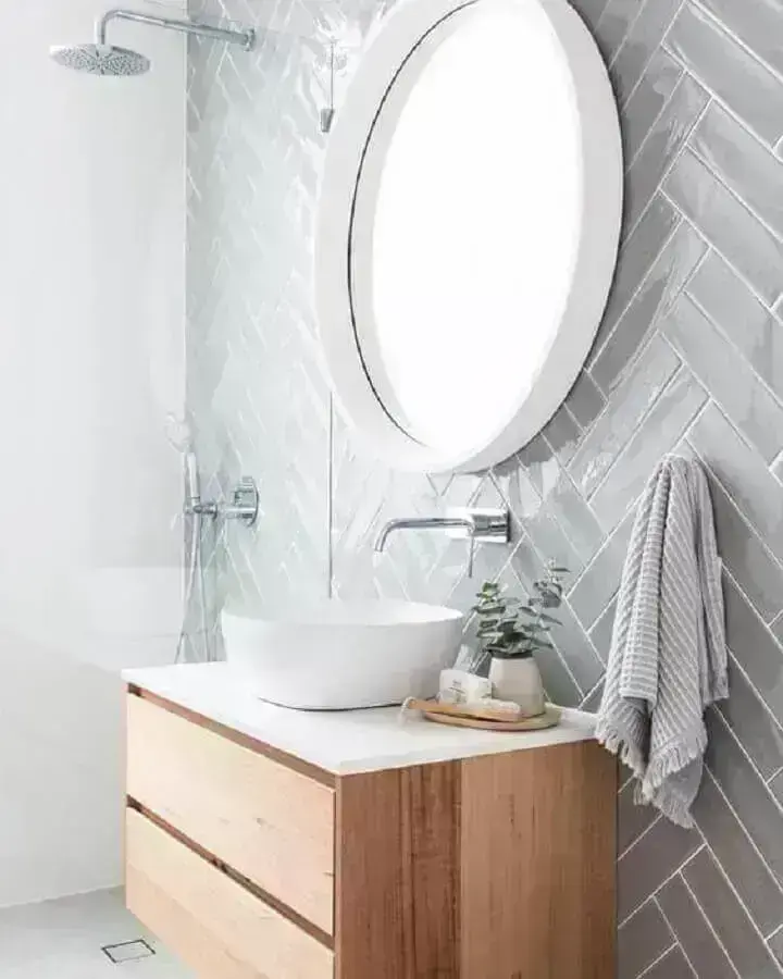 Decoração com espelho redondo e azulejo de banheiro cinza claro