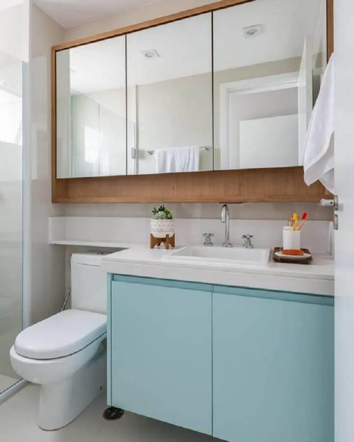 Decoração com gabinete azul pastel e espelheira para banheiro de madeira