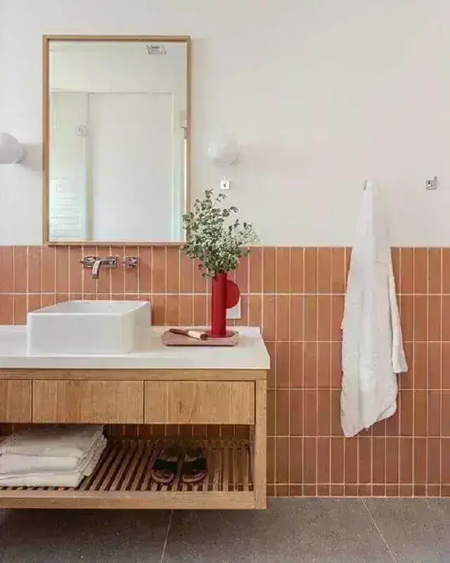 Decoração com gabinete suspenso e azulejo de banheiro na cor coral