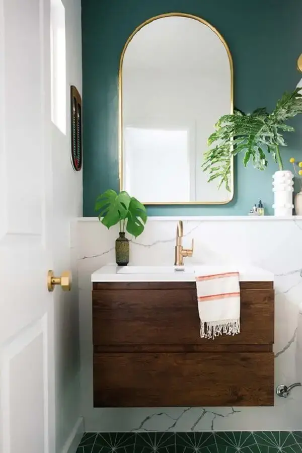 Decoração com parede verde e armário pequeno de banheiro de madeira
