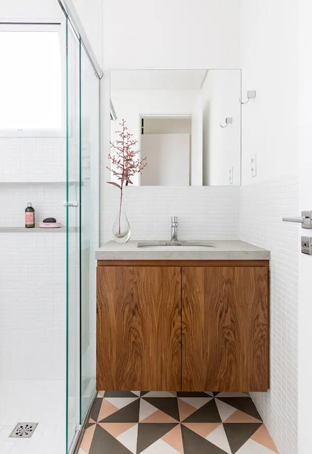 Decoração com piso geométrico e armário pequeno de banheiro de madeira