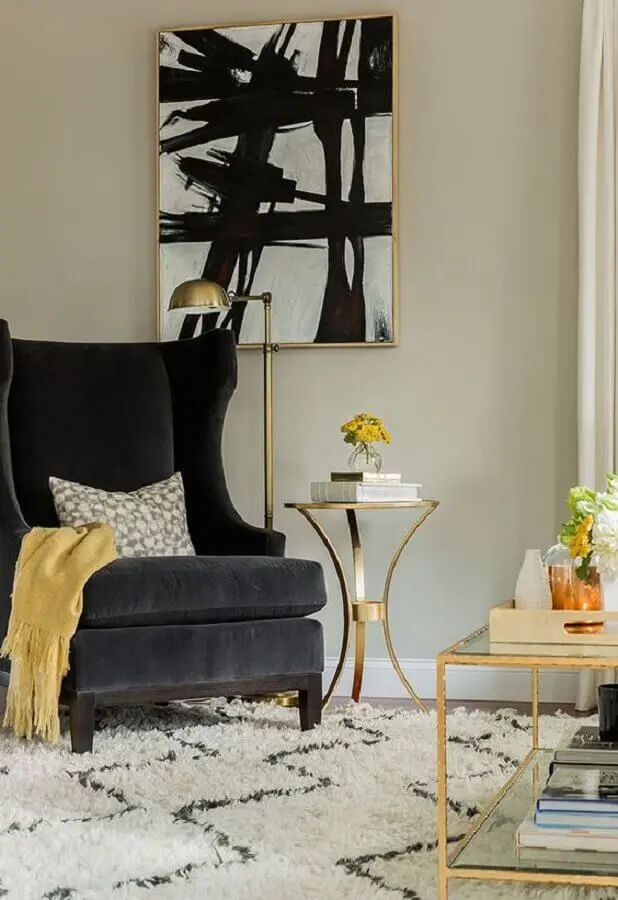 Decoração com poltrona preta para sala clássica com móveis de vidro com detalhe dourado