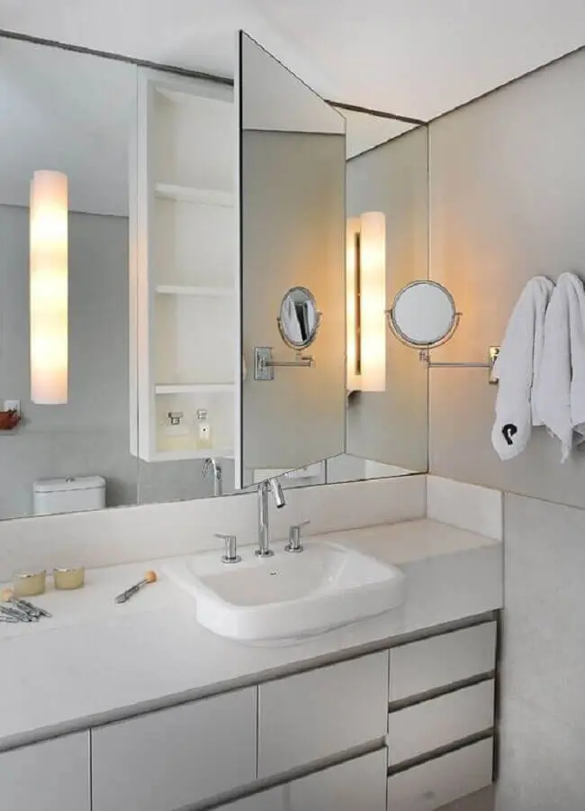 Decoração de banheiro branco com espelheira e gabinete planejado