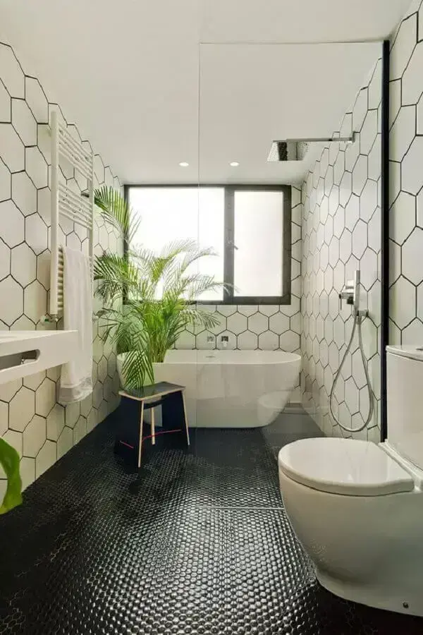 Decoração de banheiro com piso preto e revestimento hexagonal para parede