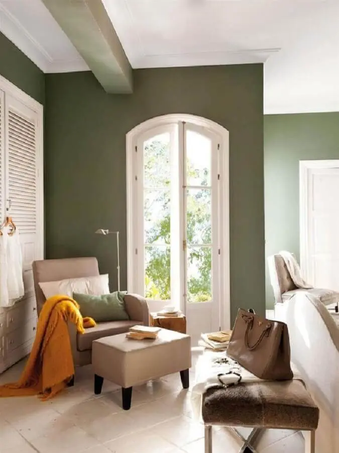 decoração de casa com parede verde oliva e poltrona bege Foto El Mueble