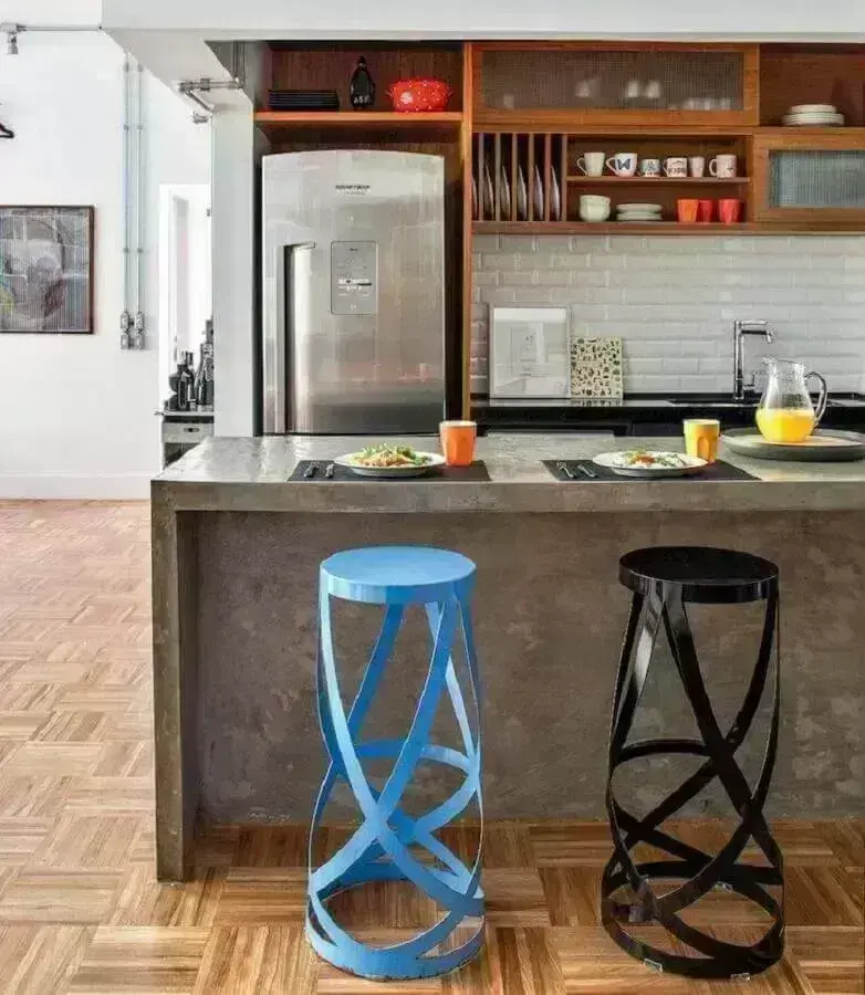 Decoração de cozinha com ilha de concreto e banqueta preta e azul moderna