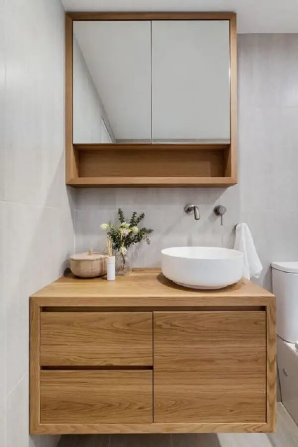 Decoração em cinza claro e madeira com armário de banheiro pequeno com cuba