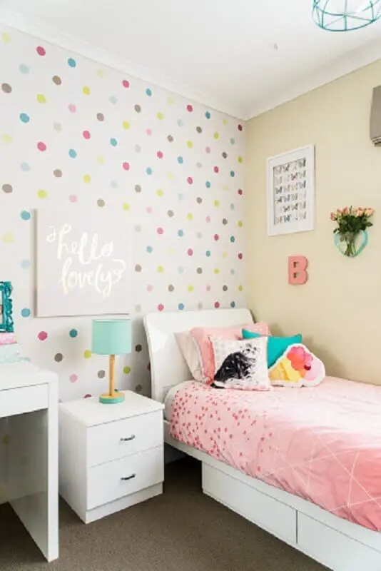 Decoração simples com papel de parede de bolinhas coloridas e almofadas para quarto infantil
