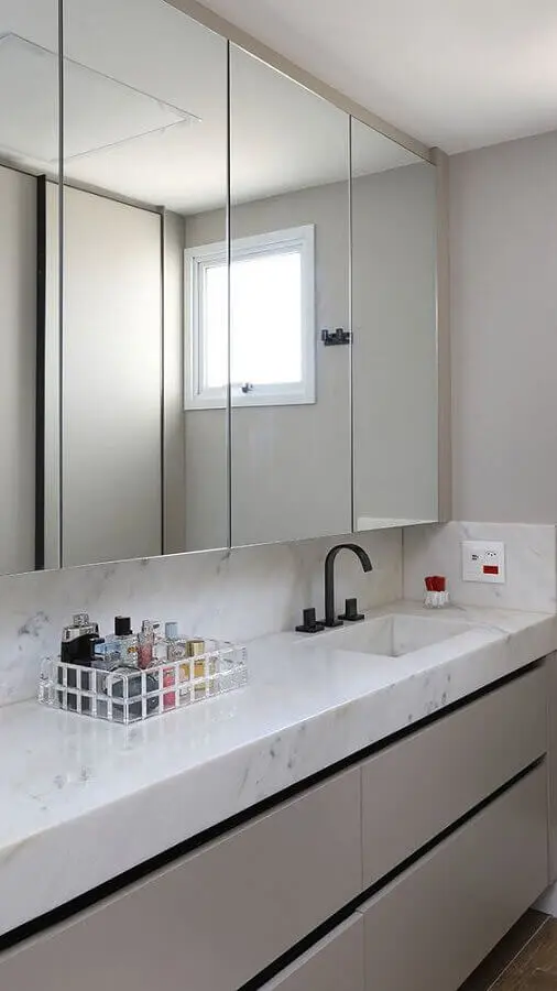 Decoração sofisticada com bancada de mármore e espelheira grande para banheiro