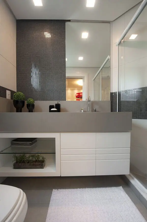 Decoração sofisticada em cinza e branco com armário de banheiro planejado pequeno
