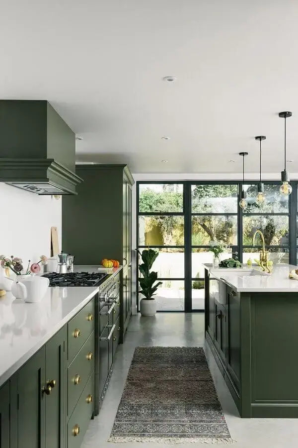 Decoração sofisticada para cozinha planejada com ilha e armários na cor verde escuro