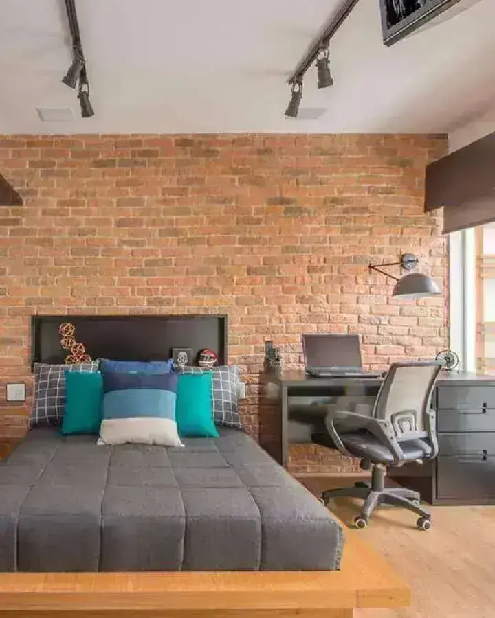Escrivaninha preta para decoração de home office no quarto de casal com parede tijolinho