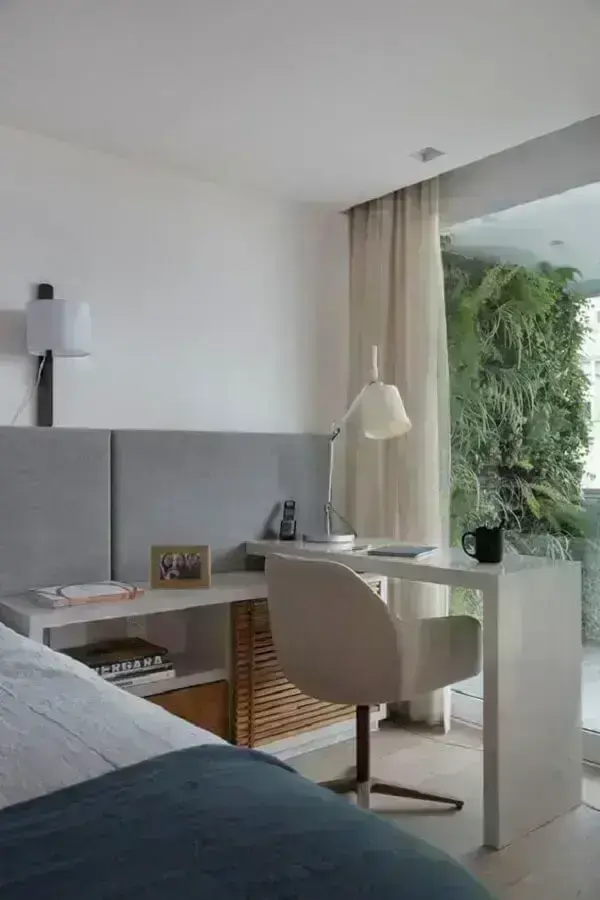 Home office no quarto de casal moderno decorado em tons de cinza