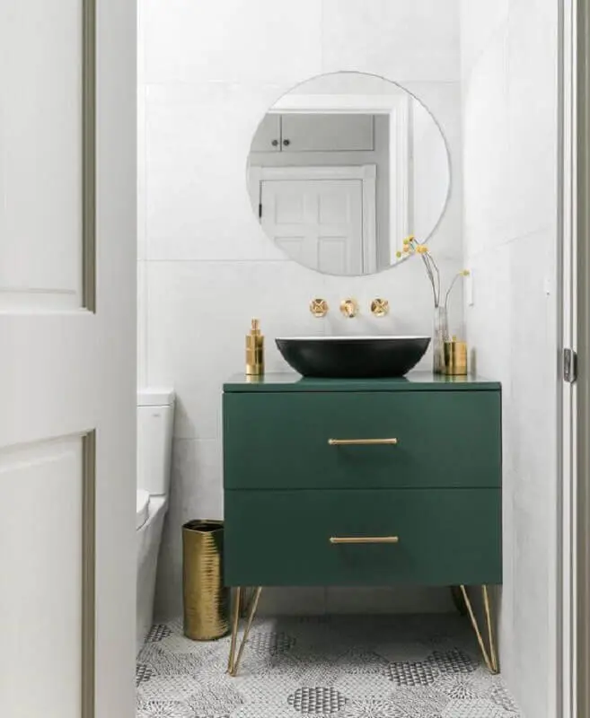 Modelo de armário para banheiro pequeno verde escuro com detalhes em dourado